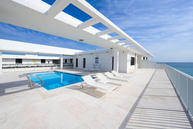 view of pool with a patio and a water view