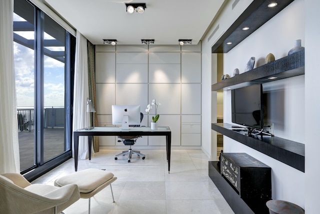 office area with a wall of windows and light tile patterned floors