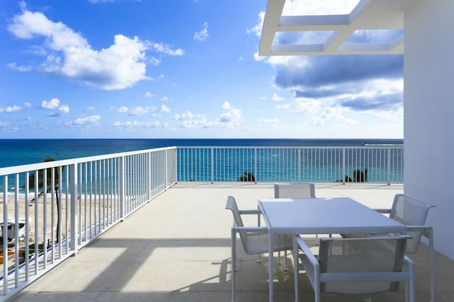 balcony featuring a water view and a beach view