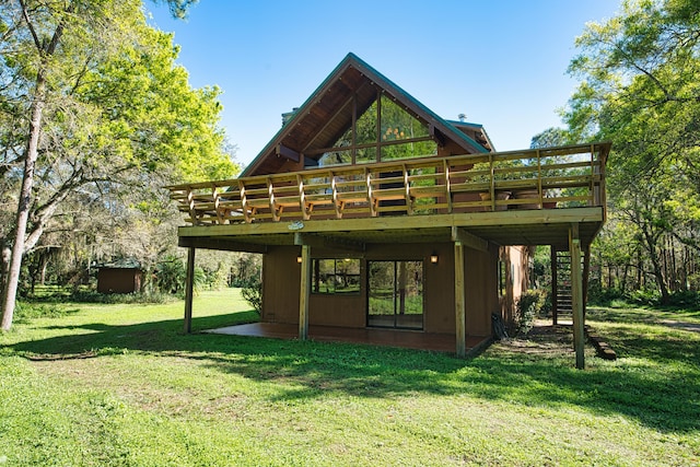 rear view of property featuring a lawn and a deck