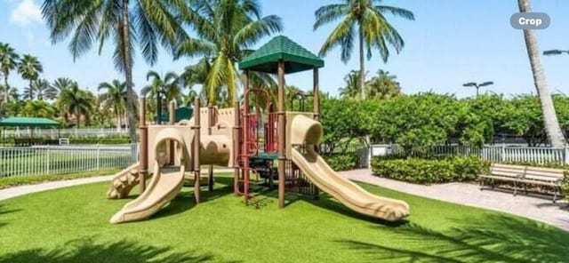 community jungle gym featuring fence and a yard