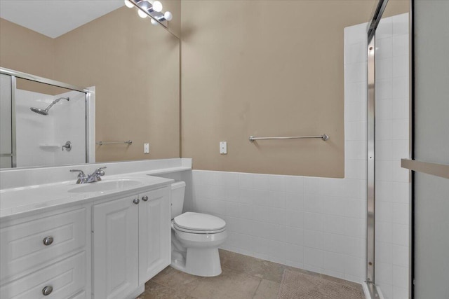 full bathroom featuring toilet, tiled shower, and vanity