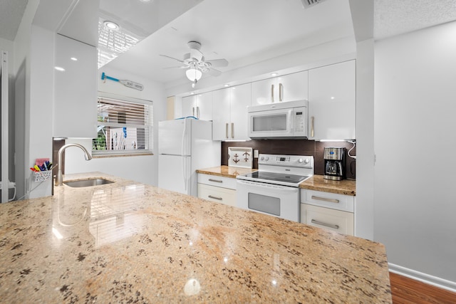 kitchen with white appliances, ceiling fan, dark wood-type flooring, sink, and white cabinets