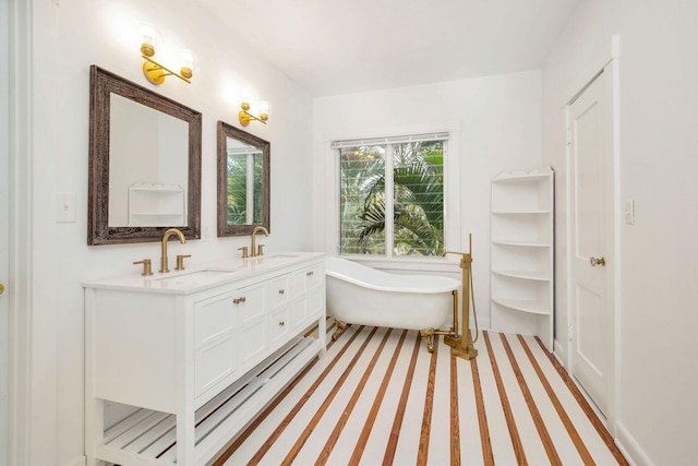 bathroom featuring a sink, a soaking tub, and double vanity