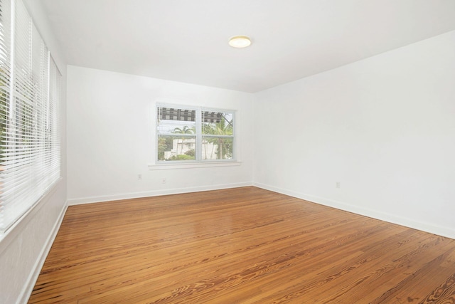 unfurnished room with baseboards and light wood-style floors