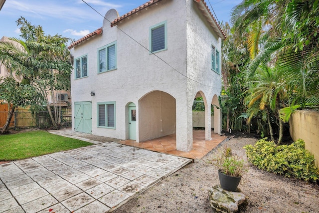 back of property featuring a patio, a tiled roof, a fenced backyard, and stucco siding