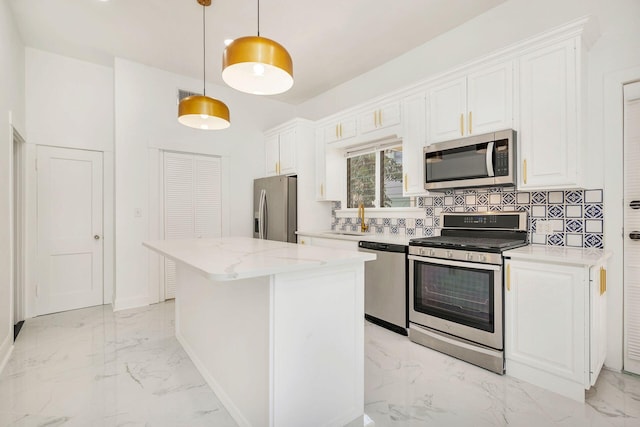 kitchen featuring white cabinets, marble finish floor, appliances with stainless steel finishes, and a kitchen island