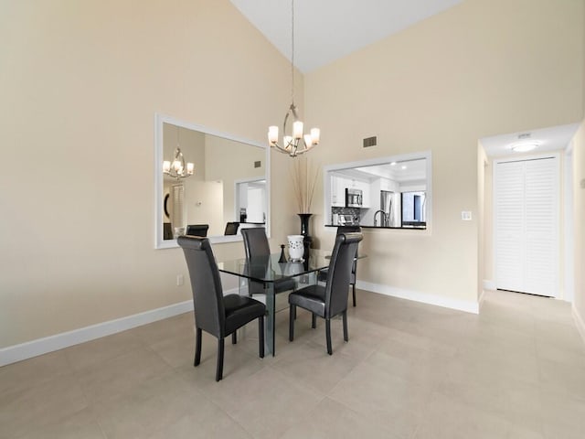 dining space with high vaulted ceiling and a chandelier