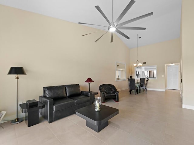 tiled living room featuring high vaulted ceiling and ceiling fan with notable chandelier