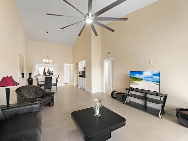 tiled living room with ceiling fan with notable chandelier and high vaulted ceiling