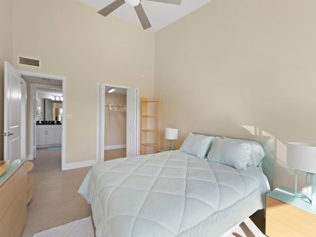 bedroom with ceiling fan, a walk in closet, a closet, and a high ceiling