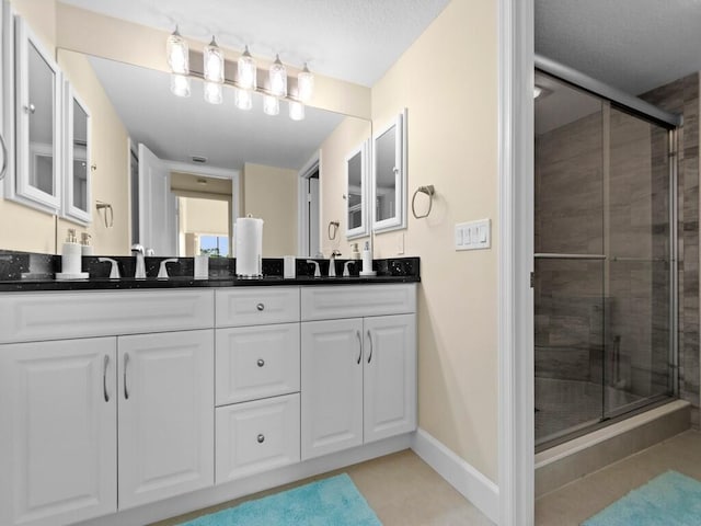 bathroom with vanity, an enclosed shower, and tile patterned floors