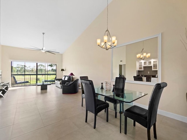 tiled dining space featuring high vaulted ceiling and ceiling fan with notable chandelier