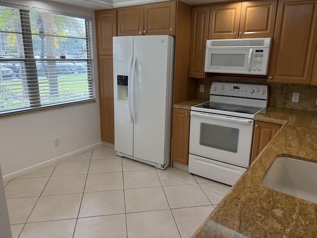 kitchen with white appliances, sink, decorative backsplash, light stone countertops, and light tile patterned floors