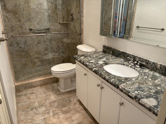 bathroom featuring tiled shower, vanity, and toilet