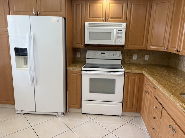 kitchen with light stone countertops, white appliances, light tile patterned floors, and tasteful backsplash