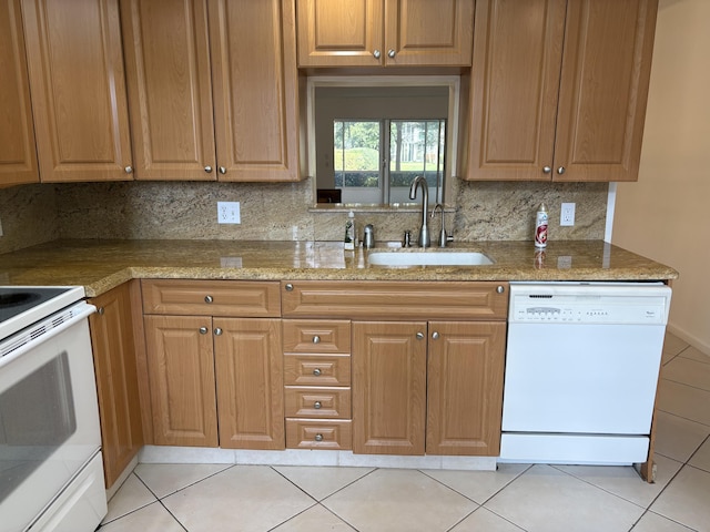 kitchen featuring sink, tasteful backsplash, light stone counters, white appliances, and light tile patterned floors