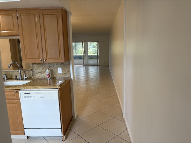 kitchen with backsplash, sink, white dishwasher, and light tile patterned flooring