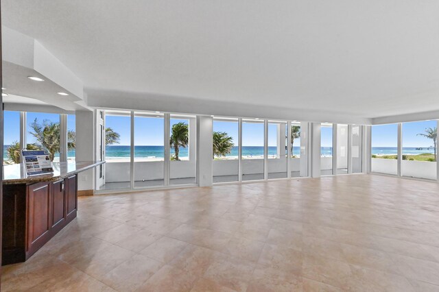 spare room featuring plenty of natural light, a water view, and light tile flooring