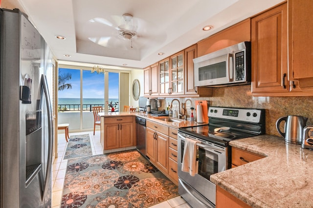 2800 S Ocean Blvd Unit 2-A, Boca Raton, FL 33432 - kitchen with light tile patterned floors, brown cabinets, a sink, appliances with stainless steel finishes, and backsplash