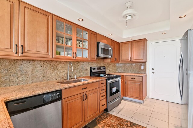 2800 S Ocean Blvd Unit 2-A, Boca Raton, FL 33432 - kitchen with stainless steel appliances, light tile patterned floors, brown cabinetry, and a sink