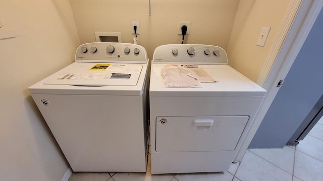 washroom with washer and dryer, laundry area, and light tile patterned floors