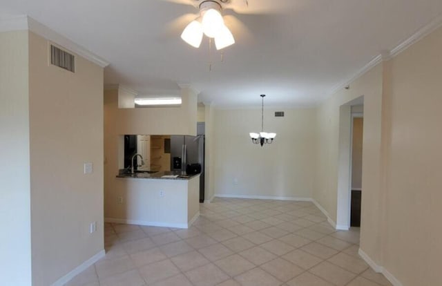 spare room featuring baseboards, visible vents, ceiling fan with notable chandelier, crown molding, and light tile patterned flooring