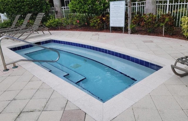 view of swimming pool featuring fence