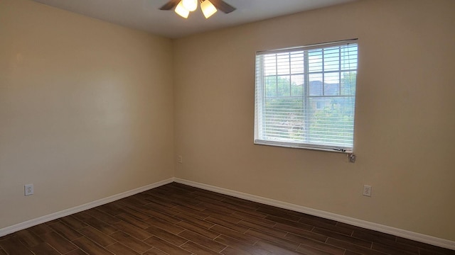 spare room with dark wood-style floors, ceiling fan, and baseboards