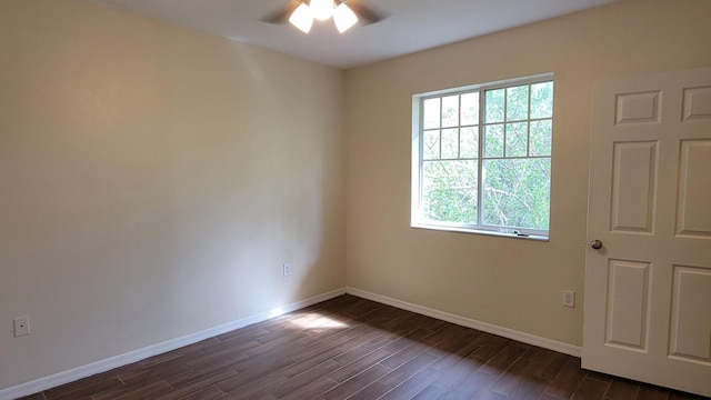 spare room with dark wood-style floors, baseboards, and a ceiling fan