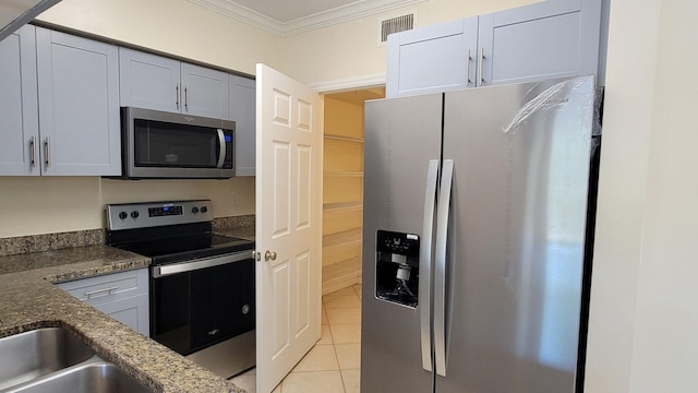 kitchen featuring light tile patterned floors, stainless steel appliances, visible vents, dark stone countertops, and crown molding