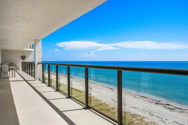 balcony with a water view and a beach view