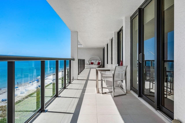 balcony featuring a water view and a view of the beach