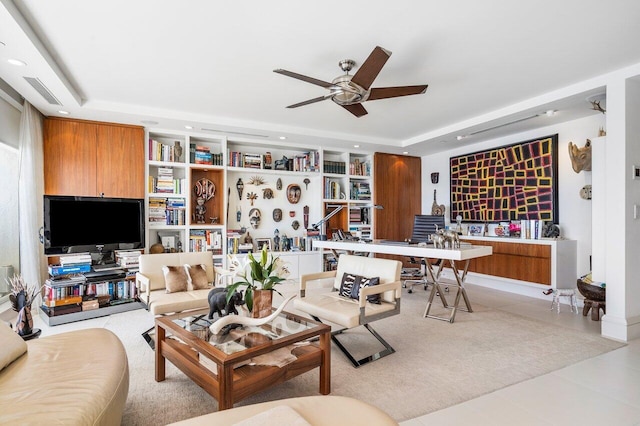 living room featuring a tray ceiling and ceiling fan