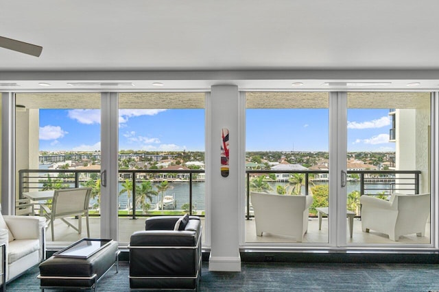 doorway with plenty of natural light, dark colored carpet, and a water view