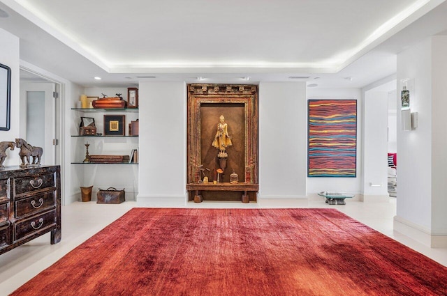 living room with light tile patterned floors and a tray ceiling