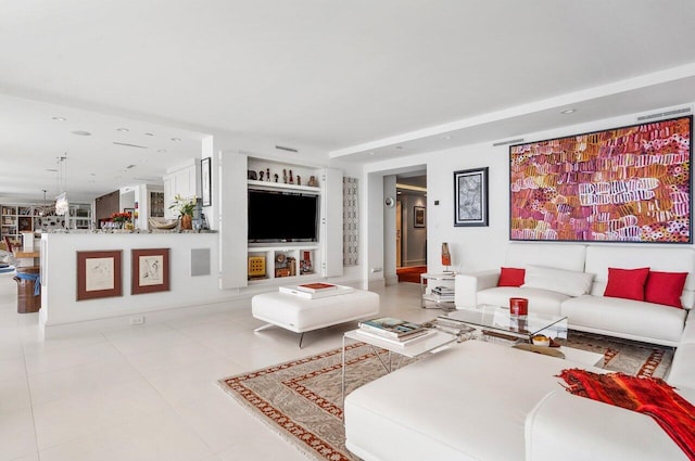 living room with light tile patterned flooring and built in shelves