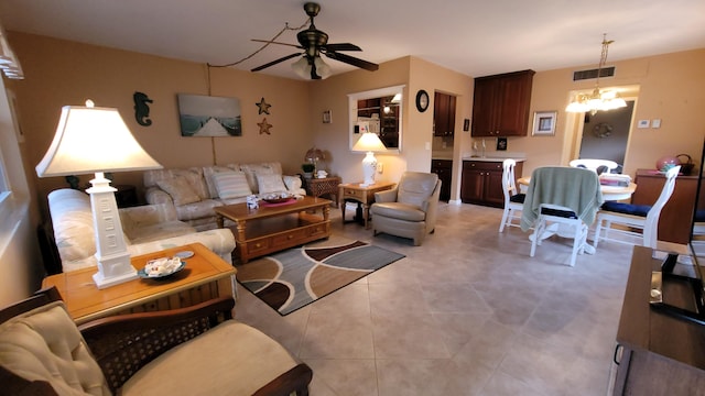 living room with light tile patterned floors, sink, and ceiling fan with notable chandelier