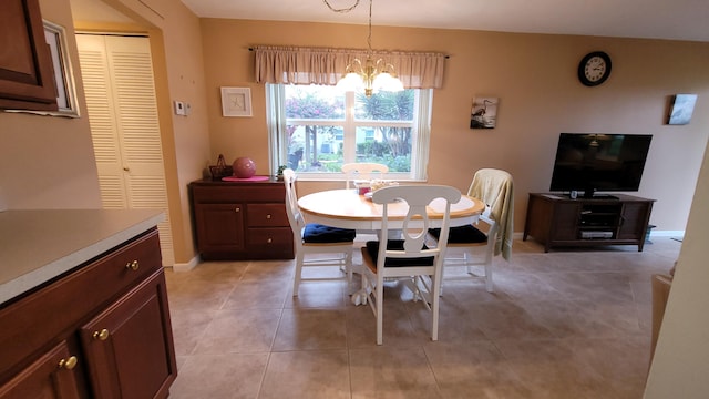 dining area featuring light tile patterned floors and an inviting chandelier