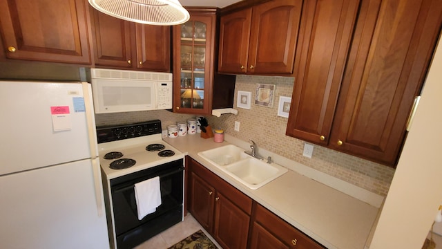 kitchen with sink, light tile patterned floors, white appliances, and decorative backsplash