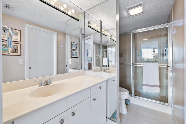 bathroom featuring tile patterned floors, vanity, toilet, and a shower with door