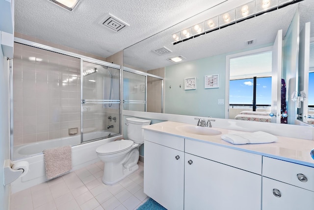 full bathroom featuring tile patterned floors, bath / shower combo with glass door, a textured ceiling, vanity, and toilet