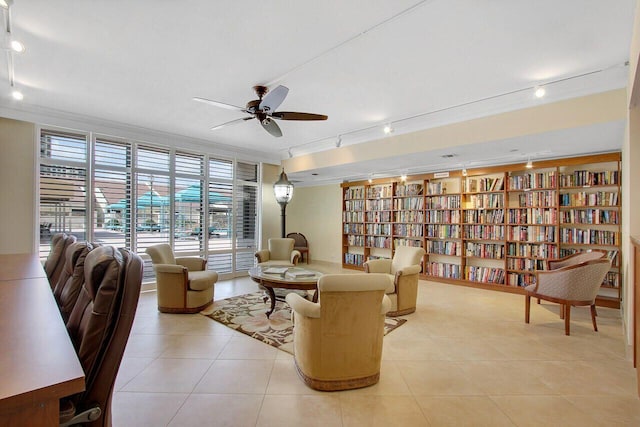 living room featuring rail lighting, crown molding, and light tile patterned flooring