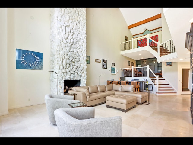 living room with high vaulted ceiling and a stone fireplace