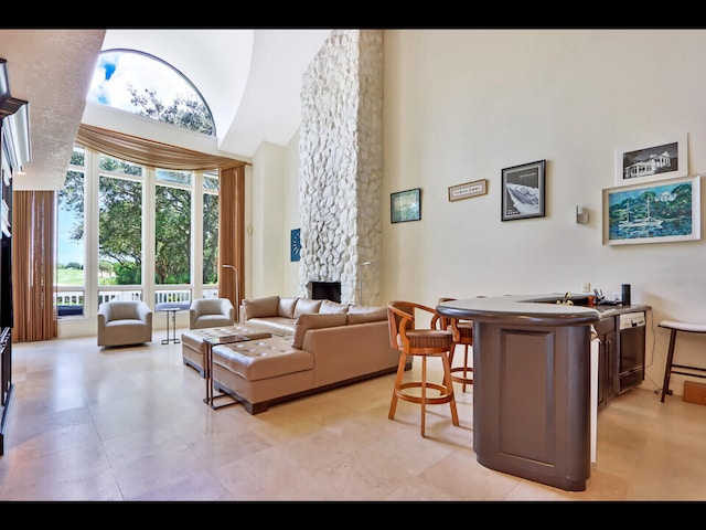 living room featuring a fireplace and a high ceiling