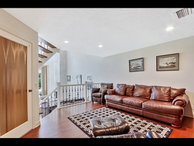 living room with a textured ceiling and hardwood / wood-style floors