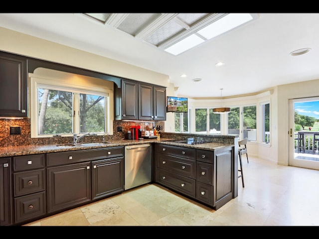 kitchen featuring dishwasher, sink, dark stone counters, and tasteful backsplash