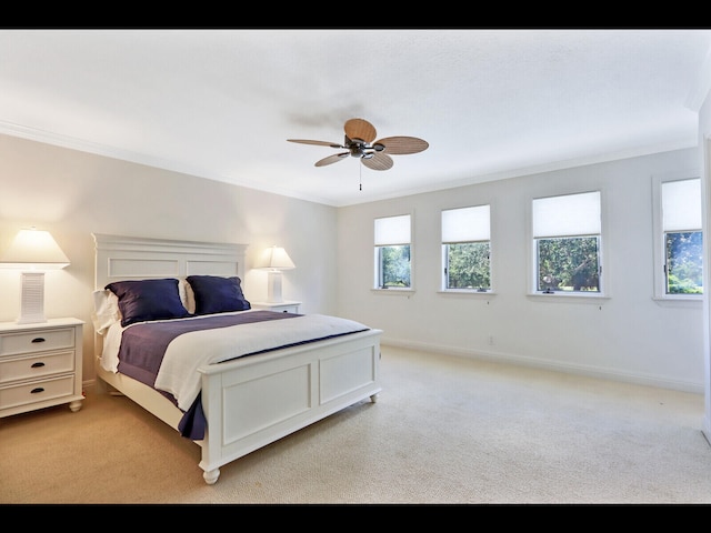 bedroom with light carpet, crown molding, and ceiling fan