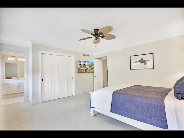 bedroom featuring light carpet, ensuite bath, ceiling fan, and a closet