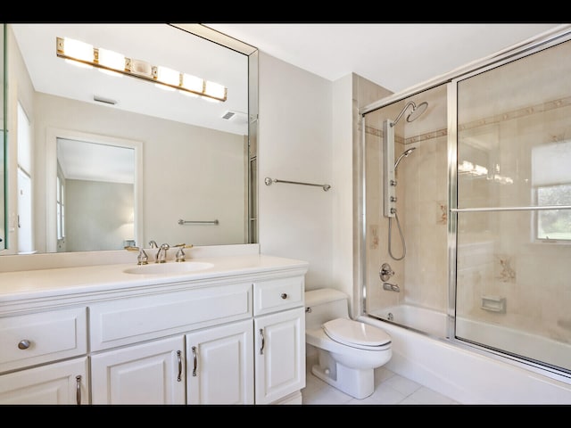 full bathroom featuring shower / bath combination with glass door, vanity, toilet, and tile patterned floors